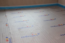 Warstwa izolacyjna pod ogrzewaniem podłogowym pełni kilka funkcji jednocześnie.